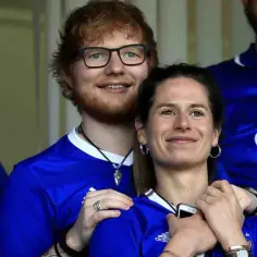Ed Sheeran i jego żona Cherry Seaborn w niebieskich koszulkach piłkarskich.